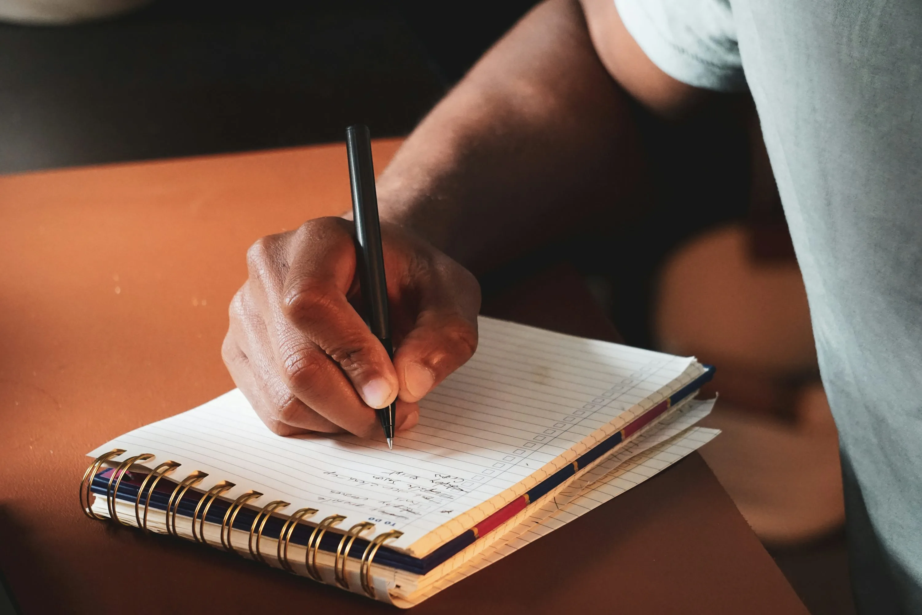 Pessoa escrevendo em um caderno de anotações